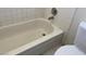 Bathroom featuring white ceramic tile walls and a bathtub with a matching white toilet at 7732 Blackbird Ave, Las Vegas, NV 89145