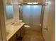 Bathroom featuring double sinks, frosted glass shower door, tile flooring, and wood vanity at 7732 Blackbird Ave, Las Vegas, NV 89145