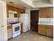 Kitchen featuring wooden cabinets, white appliances, and tile floors at 7732 Blackbird Ave, Las Vegas, NV 89145