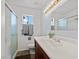 Bright bathroom featuring a glass door shower, large vanity, and decorative light fixture at 7797 Hauck St, Las Vegas, NV 89139