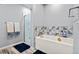 Bathroom with a soaking tub, decorative tile, and a frosted glass shower door at 7797 Hauck St, Las Vegas, NV 89139