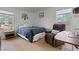 Bright bedroom featuring a cozy recliner, natural light from two windows and light wood floors at 7797 Hauck St, Las Vegas, NV 89139