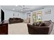 Cozy living room with neutral carpet, ceiling fan, and glass doors to the backyard at 7797 Hauck St, Las Vegas, NV 89139