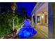 Stunning backyard featuring unique pool with waterfall, covered patio, and manicured landscaping at 812 Eaglewood Dr, Las Vegas, NV 89144