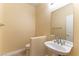 Cozy powder room featuring a pedestal sink, tile flooring and a large mirror reflecting a white door at 812 Eaglewood Dr, Las Vegas, NV 89144