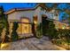 Elegant home exterior featuring a stone patio and lush landscaping with upward growing ivy at 812 Eaglewood Dr, Las Vegas, NV 89144