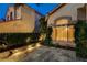 Elegant home exterior featuring a stone patio and lush landscaping with upward growing ivy at 812 Eaglewood Dr, Las Vegas, NV 89144