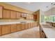 Bright kitchen featuring wood cabinetry, tile flooring, and large windows overlooking backyard at 812 Eaglewood Dr, Las Vegas, NV 89144