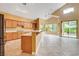 Bright, open kitchen with wood cabinets, island, tile floors, and sliding glass doors at 812 Eaglewood Dr, Las Vegas, NV 89144