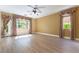 Spacious living room featuring laminate floors, two windows with custom curtains and a ceiling fan at 812 Eaglewood Dr, Las Vegas, NV 89144