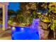 Beautiful pool with waterfall feature surrounded by lush landscaping and ambient lighting at 812 Eaglewood Dr, Las Vegas, NV 89144