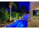 Beautiful backyard pool with rock waterfall feature, lush landscaping, and covered patio at 812 Eaglewood Dr, Las Vegas, NV 89144