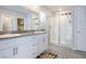 Bright bathroom features a double sink vanity with white cabinets and a glass-enclosed shower at 9871 Magnus Ct, Las Vegas, NV 89178