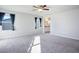 Bright bedroom with plush carpet, large windows, and a ceiling fan, offering a comfortable living space at 9871 Magnus Ct, Las Vegas, NV 89178