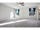 Comfortable bedroom featuring carpet, large windows, and a ceiling fan, providing a relaxing atmosphere at 9871 Magnus Ct, Las Vegas, NV 89178