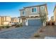 View of a two-story home with well-manicured front yard and a paved driveway at 9871 Magnus Ct, Las Vegas, NV 89178