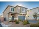 Charming two-story home featuring a covered entry, stone landscaping, and an attached garage at 9871 Magnus Ct, Las Vegas, NV 89178