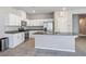Well-equipped kitchen with a central island, white cabinetry, stainless steel appliances, and granite countertops at 9871 Magnus Ct, Las Vegas, NV 89178