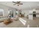 Open-concept living room and kitchen with ample natural light, neutral tones, and modern furnishings at 9871 Magnus Ct, Las Vegas, NV 89178