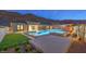 An inviting backyard pool and spa with a modern design and lush green grass at 10048 Copper Edge Rd, Las Vegas, NV 89148