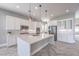 Spacious kitchen boasts white cabinets, quartz counters, pendant lighting, and stainless steel appliances at 10048 Copper Edge Rd, Las Vegas, NV 89148