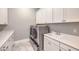 Laundry room with white cabinets, modern appliances, and a utility sink at 10048 Copper Edge Rd, Las Vegas, NV 89148
