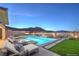 Stunning backyard pool area with sun loungers and lush green lawn, offering a tranquil outdoor retreat at 10048 Copper Edge Rd, Las Vegas, NV 89148