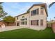 Spacious backyard featuring an artificial lawn, a brick perimeter wall, and mature trees at 10501 Haywood Dr, Las Vegas, NV 89135