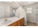 Bathroom featuring double sinks, wood cabinets, a wide mirror, and walk-in shower at 10501 Haywood Dr, Las Vegas, NV 89135