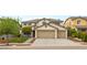 Two-story home featuring a three-car garage, well-maintained lawn and mature landscaping at 10501 Haywood Dr, Las Vegas, NV 89135