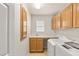 Well-lit laundry room with modern washer and dryer, ample counter space, and cabinet storage at 10501 Haywood Dr, Las Vegas, NV 89135