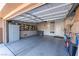 Spacious garage featuring a gray epoxy floor, white cabinets, and decorated with a variety of license plates at 10633 Tinta Ln, Las Vegas, NV 89144