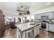 Open kitchen featuring modern gray cabinets, stainless steel appliances and an island with hanging pot rack at 10633 Tinta Ln, Las Vegas, NV 89144
