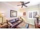 Cozy living room featuring a comfortable brown leather couch, ceiling fan, and natural light from the window at 10633 Tinta Ln, Las Vegas, NV 89144