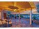 Covered patio featuring nice tile flooring, comfortable seating, and views of the desert landscaping at 10633 Tinta Ln, Las Vegas, NV 89144