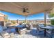 Relaxing outdoor patio area with comfortable seating, fire pit, dining table, and desert views at 10633 Tinta Ln, Las Vegas, NV 89144