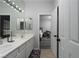Well-lit bathroom featuring double sinks and a mirror reflecting the adjacent bedroom at 10725 Bernini Dr, Las Vegas, NV 89141