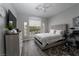 Comfortable bedroom featuring a large window, ceiling fan, and wood-look floors at 10725 Bernini Dr, Las Vegas, NV 89141