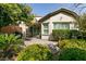 Landscaped backyard with lush greenery, trees, a covered patio, and a seating area at 11253 Piper Peak Ln, Las Vegas, NV 89138