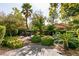 Lush backyard featuring mature trees, tropical plants, stone walkway, and a patio dining area at 11253 Piper Peak Ln, Las Vegas, NV 89138