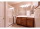 Bright bathroom featuring a glass shower enclosure, double vanity with wood cabinets, and modern lighting at 11253 Piper Peak Ln, Las Vegas, NV 89138