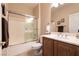 Bathroom featuring shower-tub combination with sliding glass door, toilet, and sink with wooden vanity at 11253 Piper Peak Ln, Las Vegas, NV 89138
