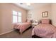 Cozy bedroom with two beds, neutral carpet, window with shutters and matching pink accents at 11253 Piper Peak Ln, Las Vegas, NV 89138