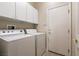 Convenient laundry room with washer, dryer, and cabinetry for storage at 11253 Piper Peak Ln, Las Vegas, NV 89138