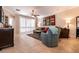 Spacious living room with comfortable seating, tile floors, and natural light from large windows at 11253 Piper Peak Ln, Las Vegas, NV 89138