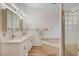 Bright bathroom with double sinks, tiled flooring, quartz countertops, and a separate tiled tub and shower at 1319 Highland Ct, Boulder City, NV 89005