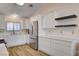 Beautiful kitchen with stainless steel refrigerator, sleek countertops, white cabinets, and wood-look floors at 1319 Highland Ct, Boulder City, NV 89005