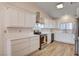 Modern kitchen with white cabinets, stainless steel appliances, quartz countertops, and wood-look tile flooring at 1319 Highland Ct, Boulder City, NV 89005
