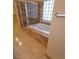 Well lit bathroom with a glass shower door, tub, and tile flooring at 1540 Sabatini Dr, Henderson, NV 89052