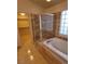 Bright bathroom featuring a soaking tub, glass block window, and tile flooring at 1540 Sabatini Dr, Henderson, NV 89052